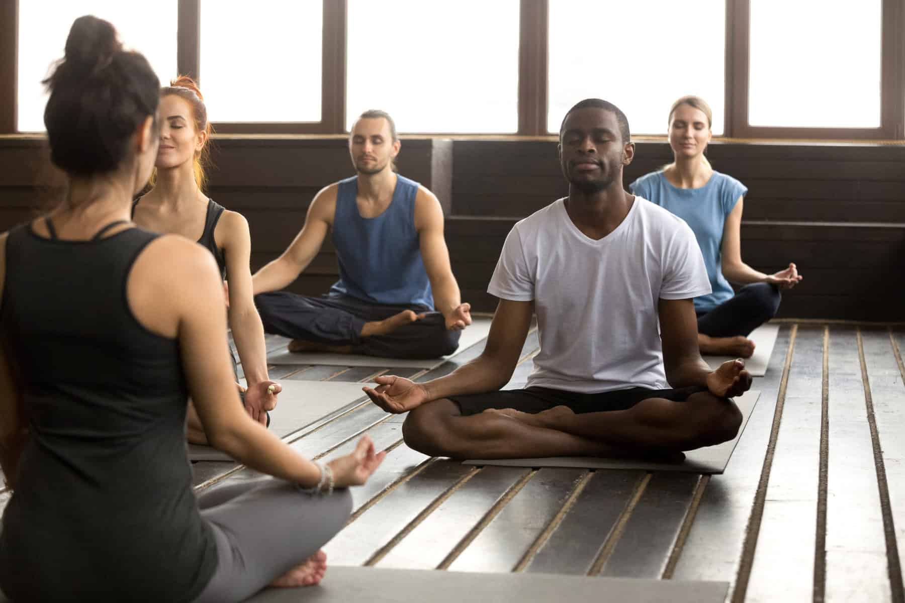 Yoga class practicing breathing and meditation. How to enhance mind-body wellness.