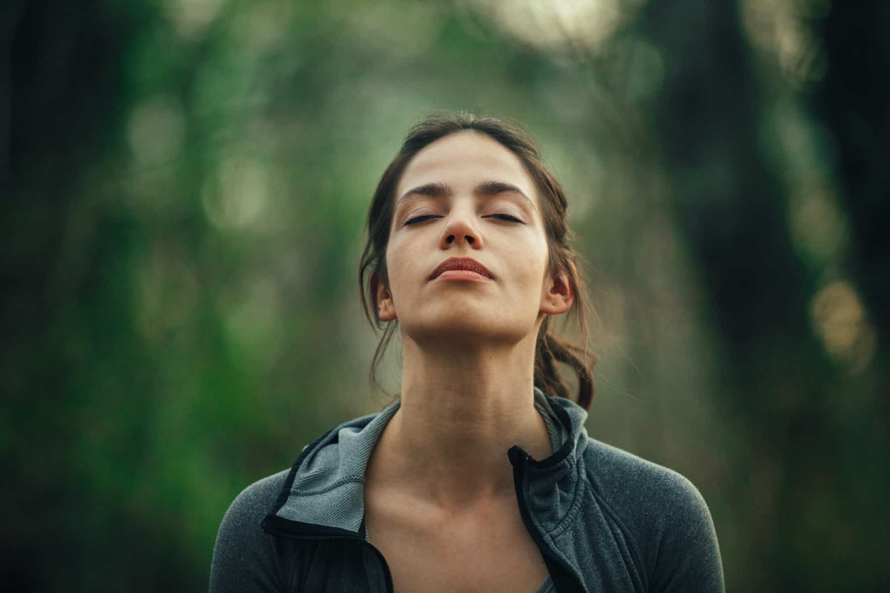 Woman in the forest breathing in meditation. Unusual meditation techniques.