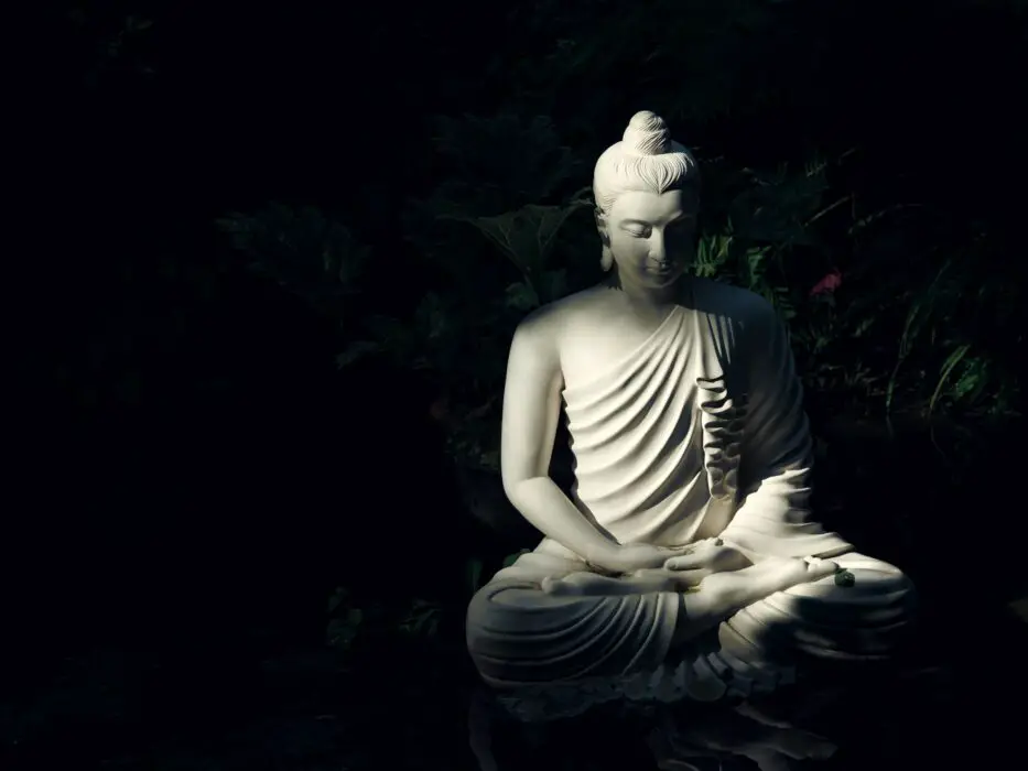Statue of Buddha cross-legged in meditation in a garden. What is the oldest meditation technique? Photo credit: Mattia Faloretti, Unsplash