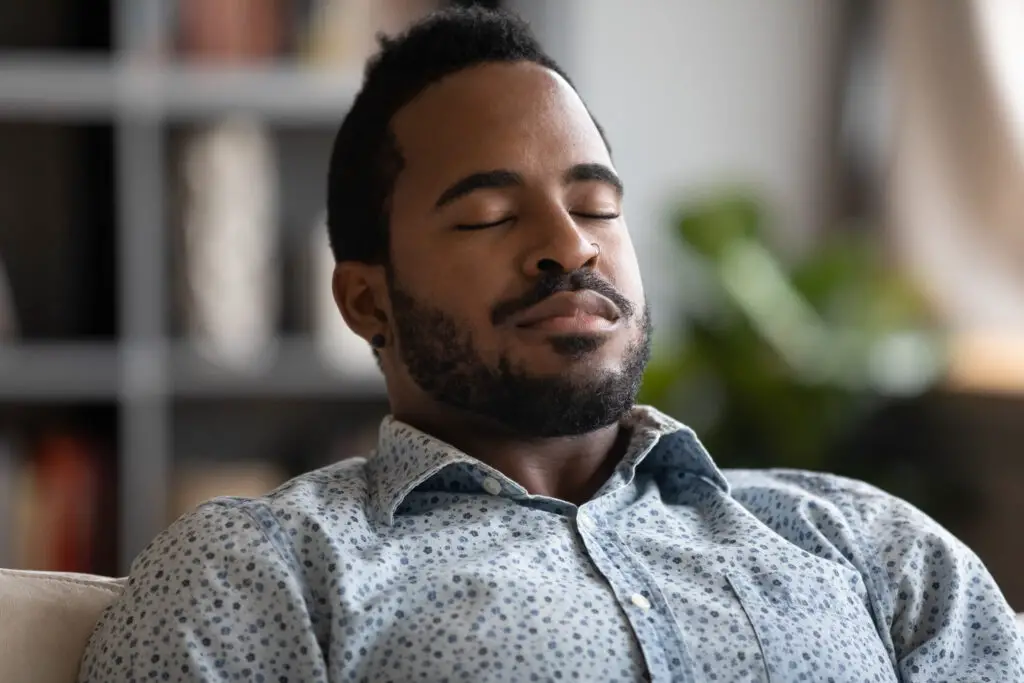 How to Create Powerful, Positive Vibes with These 3 Visualization Meditation Techniques A man sitting with eyes closed, enjoying visualization. Visualization meditation techniques.